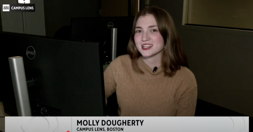 Molly Dougherty reports while sitting in front of a computer