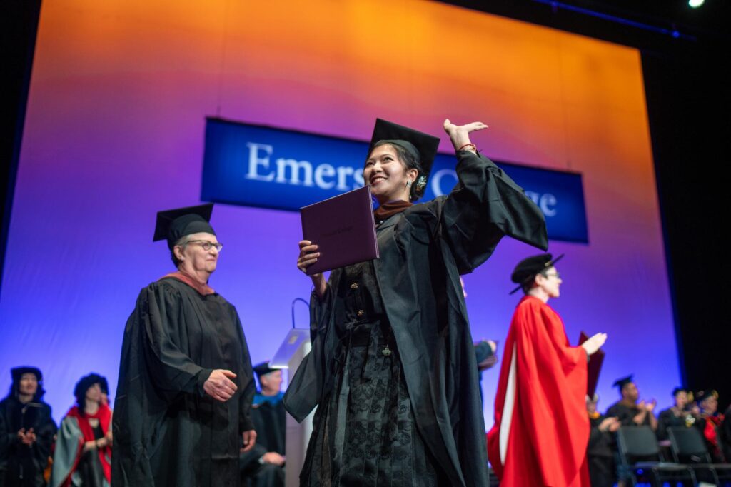 A person walks across the stage after receiving their diploma