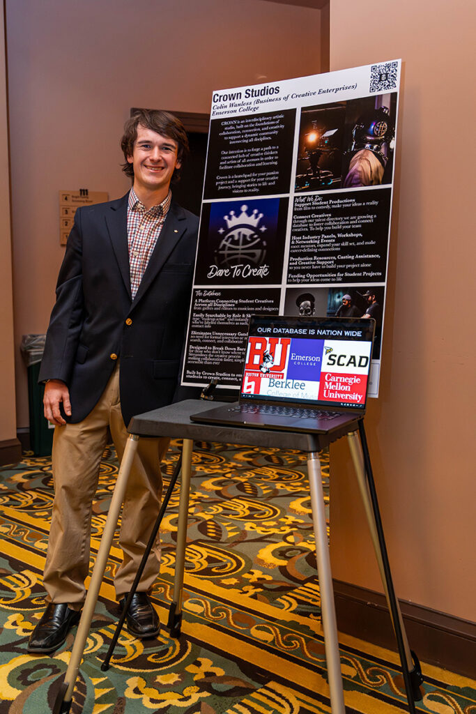 man stands next to poster board on easel