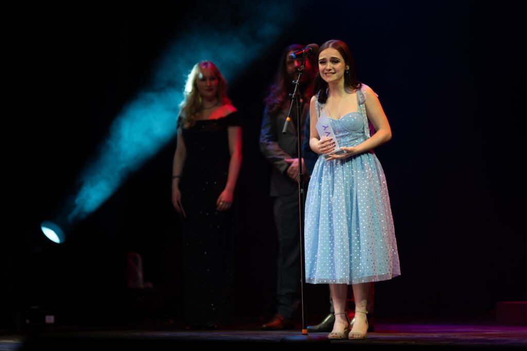Woman accepting award on stage