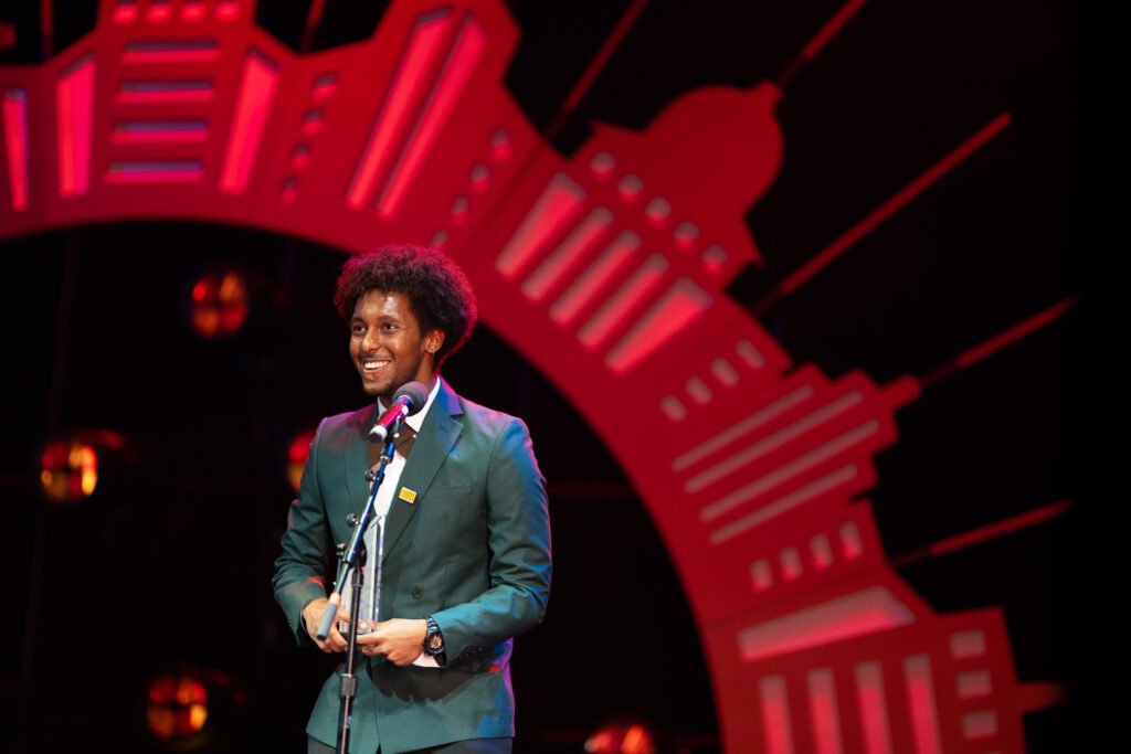 A person smiles on stage