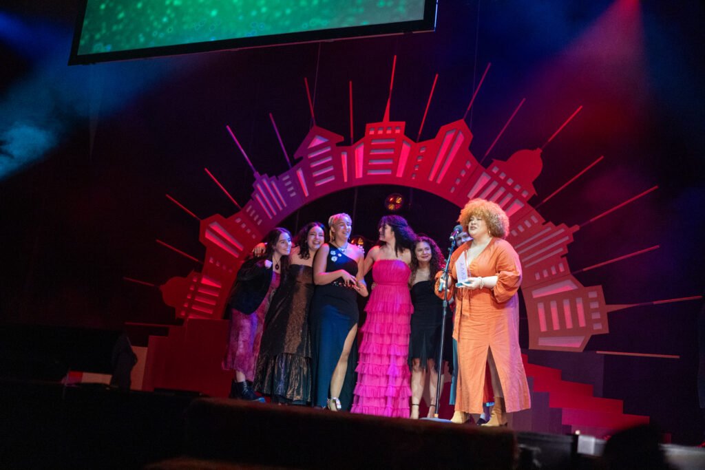 Numerous people on stage accepting an award