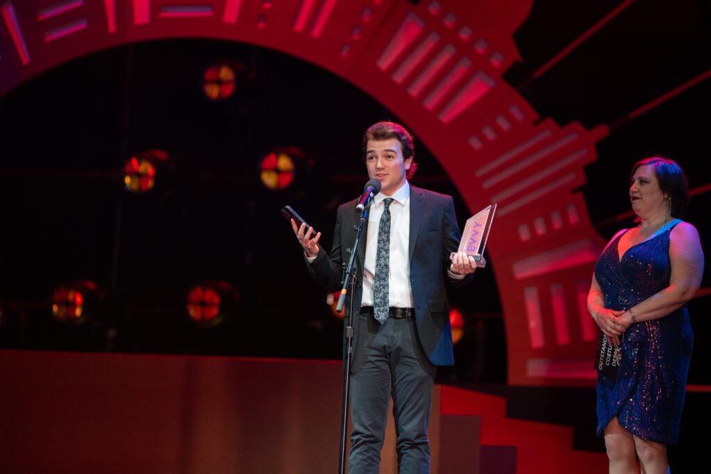 A person talks by the microphone while accepting an award