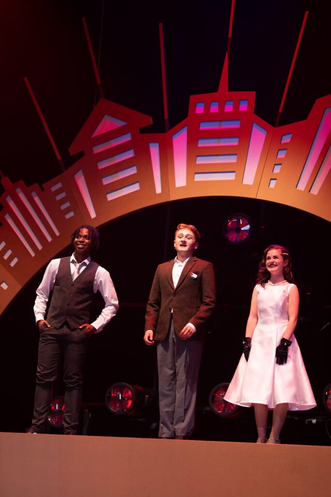 The three hosts perform on stage