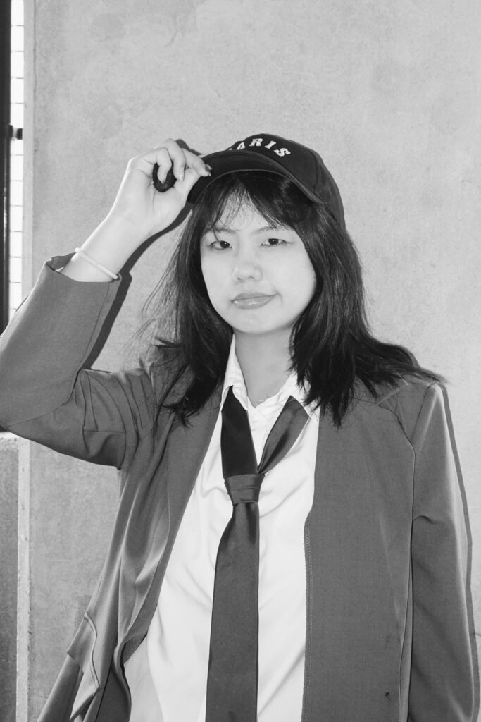 Weiyi Chen wearing a baseball, jacket and tie