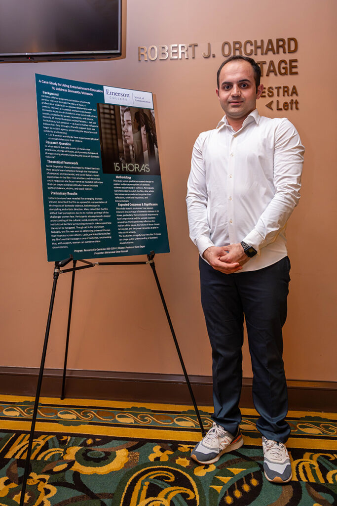 Man stands next to poster board on easel