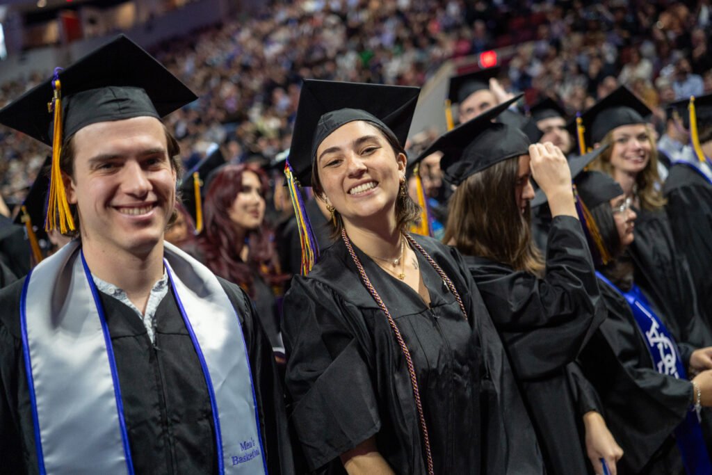 Two students smile at the camera