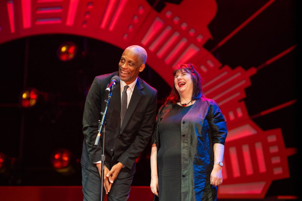 Two people talk at the microphone