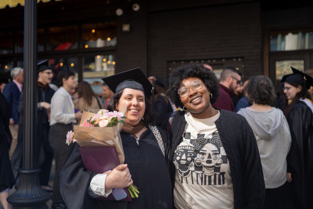 Grad posing for photo with flowers