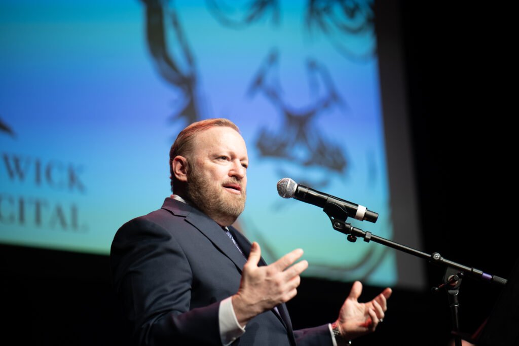 Jay Bernhardt addresses the audience at a lecturn