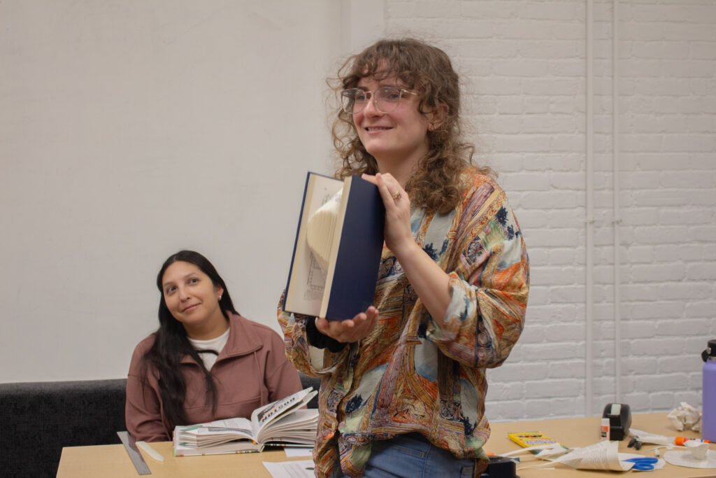 A person holds up a piece of upcycled book art that they made