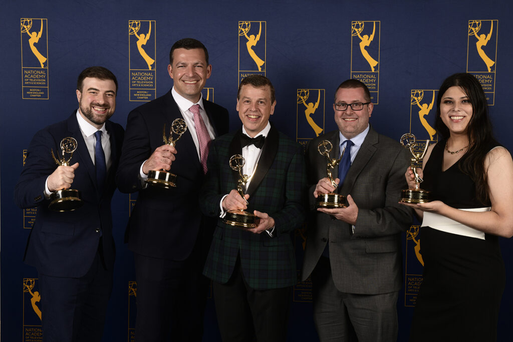 Four men and a woman hold Emmys