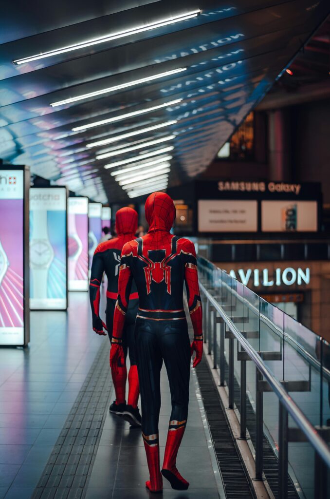 Two people dressed as Spider-Man walk away