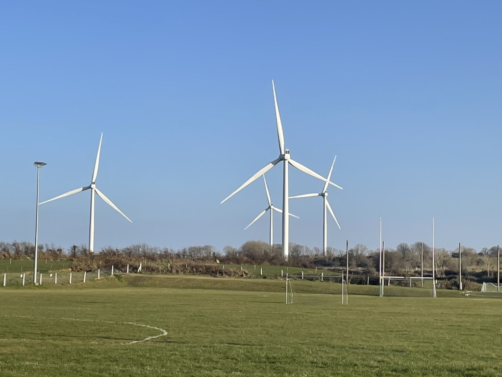 A wind turbine farm in Killala, Ireland towering over the local community youth sports pitches.