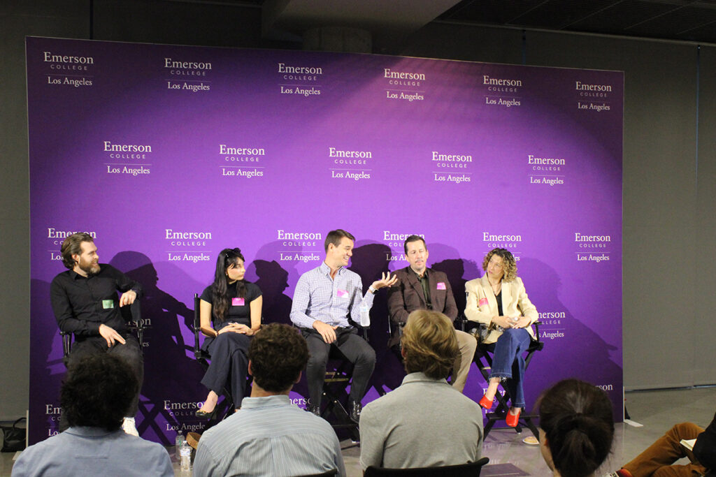 Five people sit in director's chairs in front of a purple step and repeat