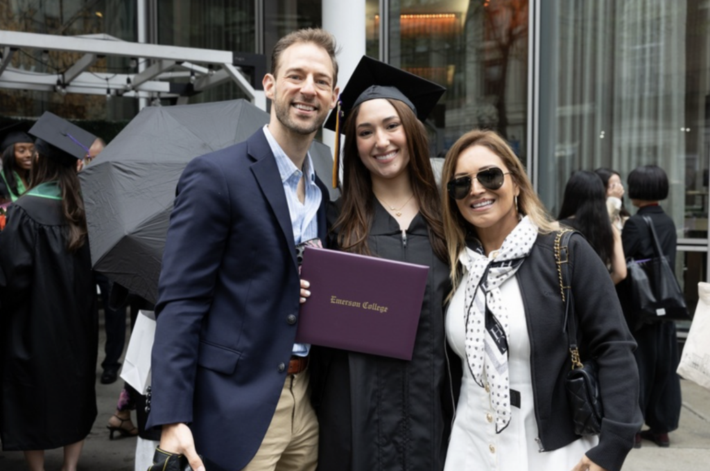 A graduate with two people pose for a photo