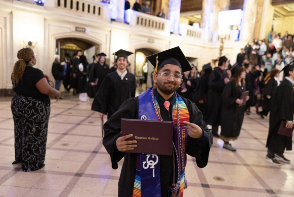 One person points at their diploma while walking through the Wang Center