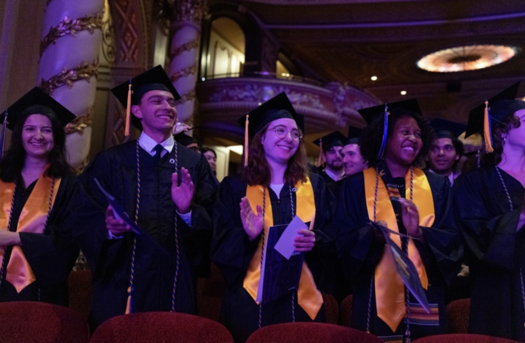 Several people clap during the ceremony