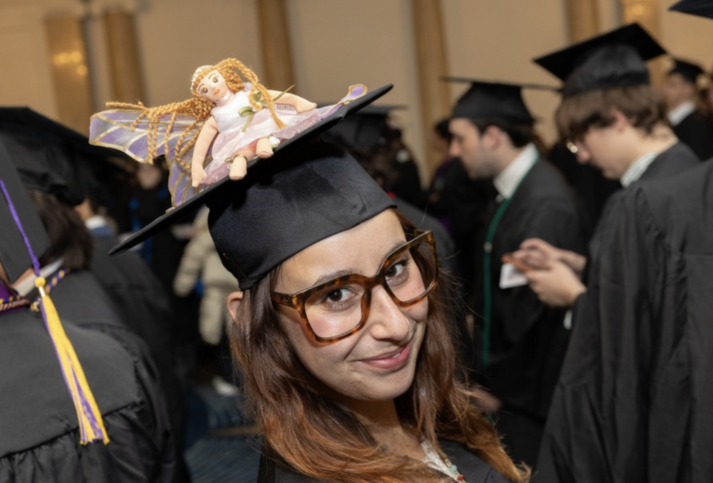 One person with a little doll on their cap