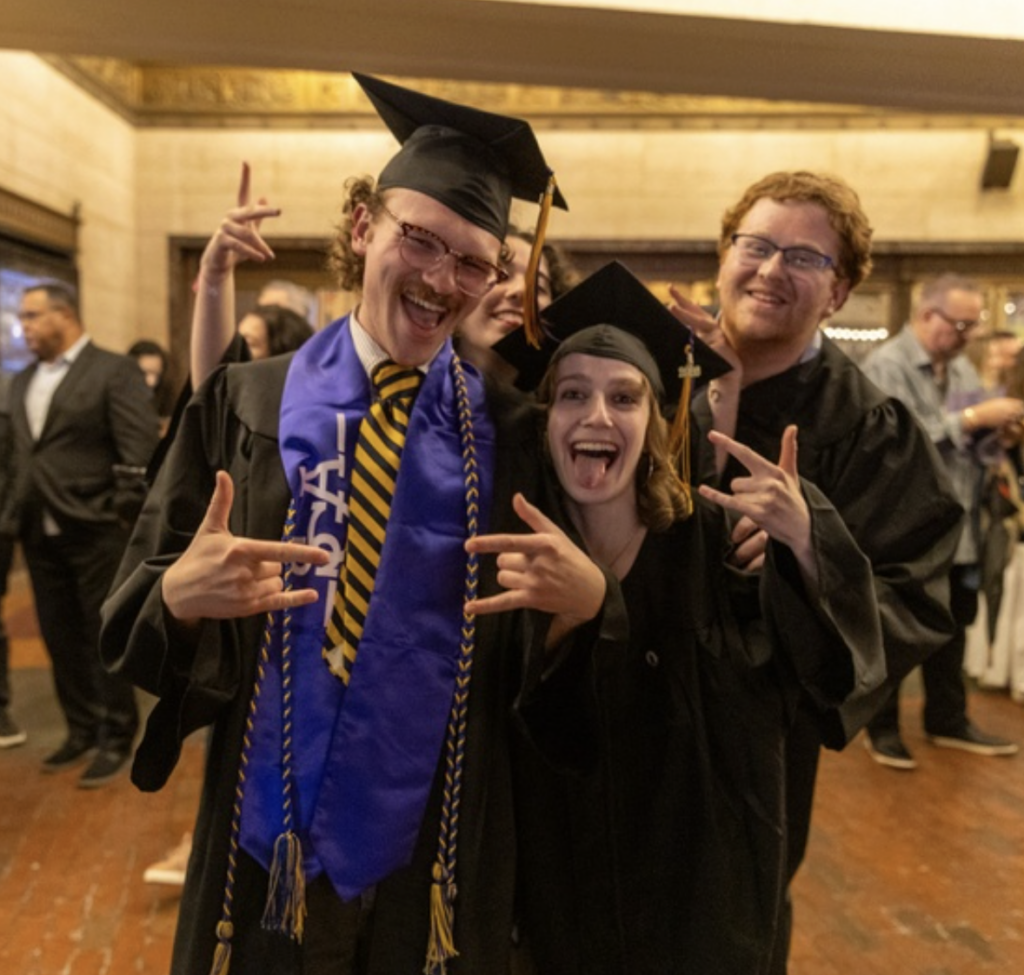 Three people give the I love you symbol with their hands