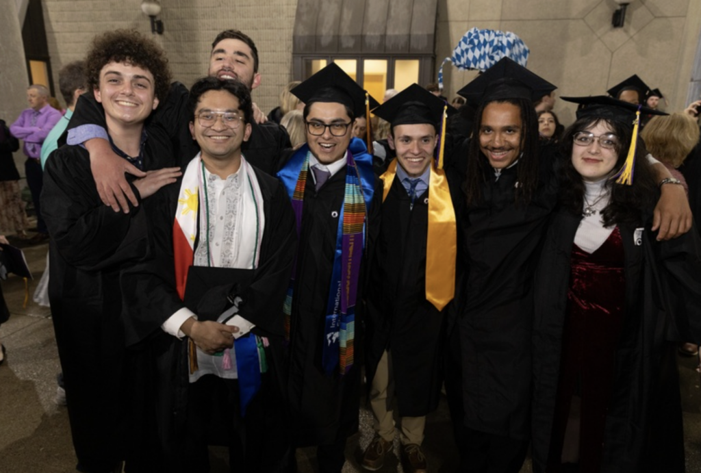 Students stand and smile together for a photo