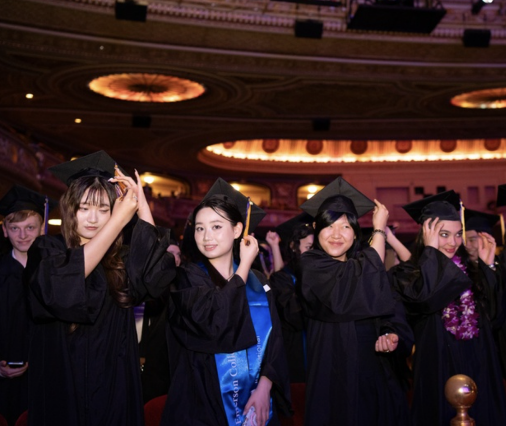 Several students move the tassel on their cap to the other side after graduating