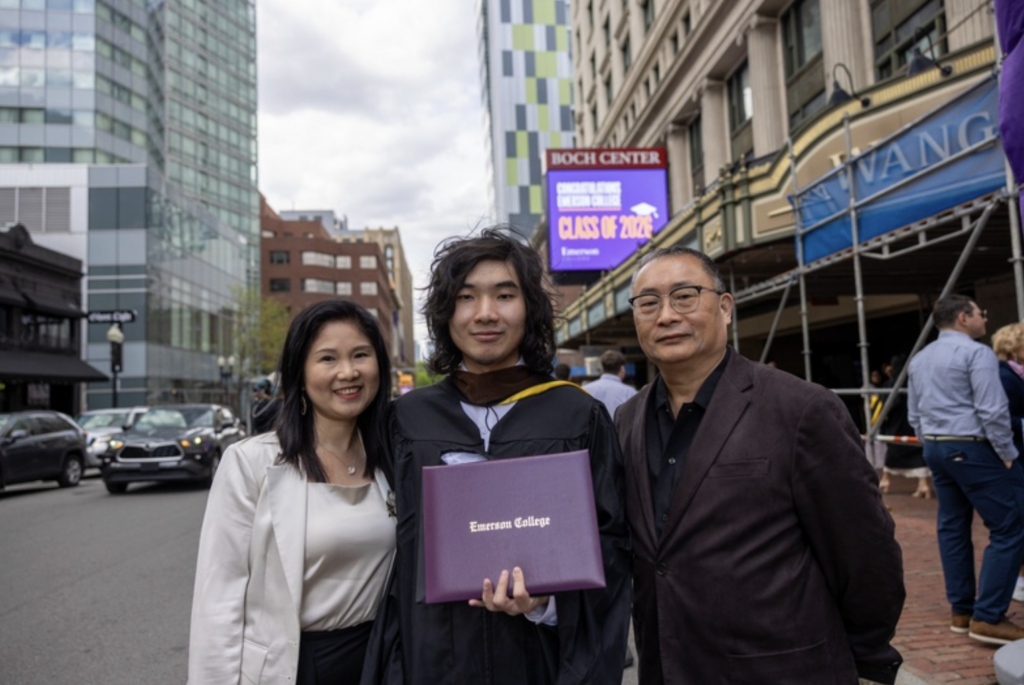 A graduate with their parents outside of the Wang Center