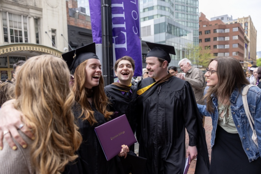 Three graduates laugh and smile together