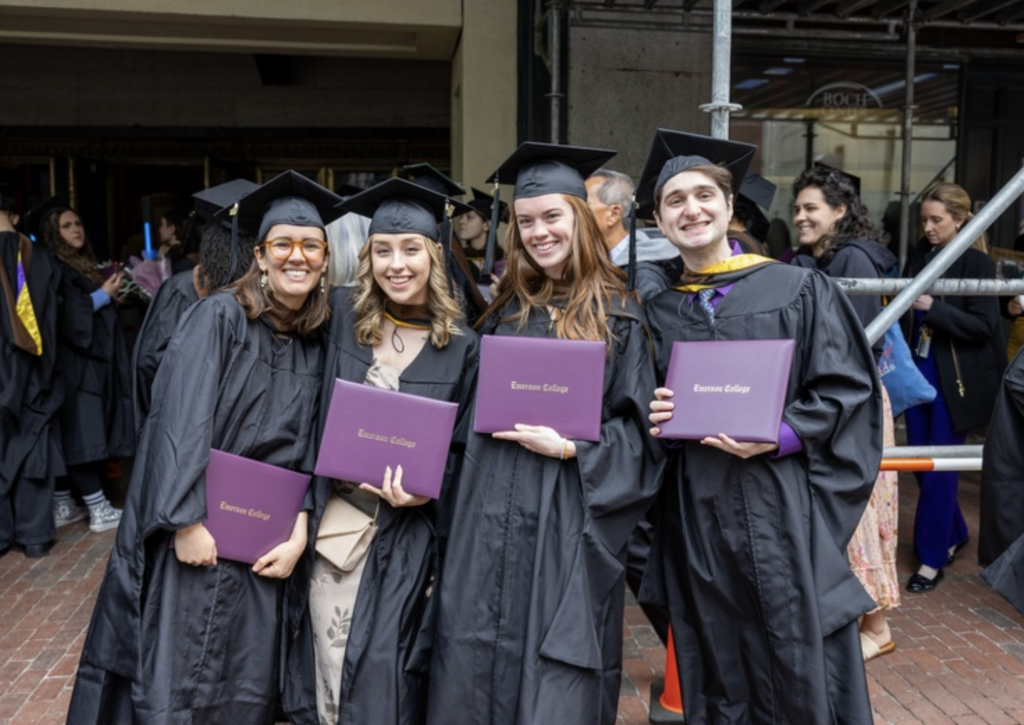 Four graduates pose for a photo holding their diplomas