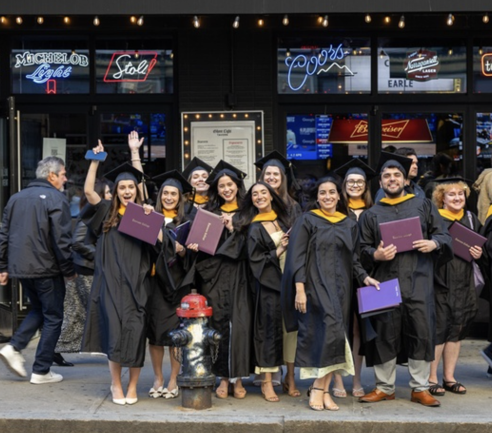 A lot of graduates pose for a photo outside