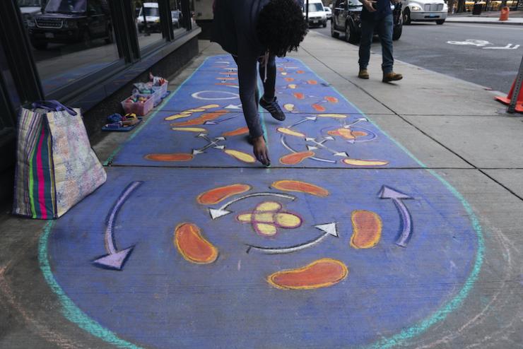 An abstract mural on the sidewalk composed of blues and reds 